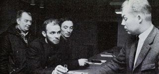 Svartvitt foto på några män som står kring en reception