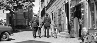 Två poliser för bort en person mellan sig.