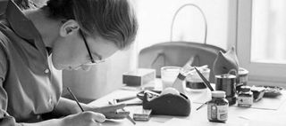 En kvinna sitter böjd över ett skrivbord