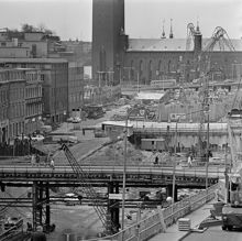 Från Vattugatan vid Brunkebergstorg mot väster över rivna kv. Elefanten. Tv. Herkulesgatan med kv. Björnen, Sköldpaddan och Snäckan. Drottninggatan går på en bro. Stadshuset är i fonden
