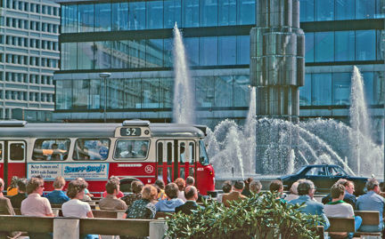 Solande människor framför obelisken på vid Sergels torg.