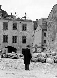Oxtorgsgatan 7. Gårdssidan under rivning, vy norrut. En man betraktar en hög med tunnor. Lite av kv. Järnplåten skymtar i bakgrunden. Här är nuvarande Sveavägen framdragen