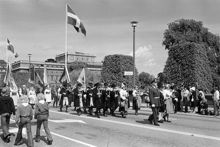 Reportage kring Kungabröllopet den 19 juni 1976. Ett spelmanslag och fanbärare i folkdräkter tågar över Norrbro mot Slottet. I fonden Operahuset