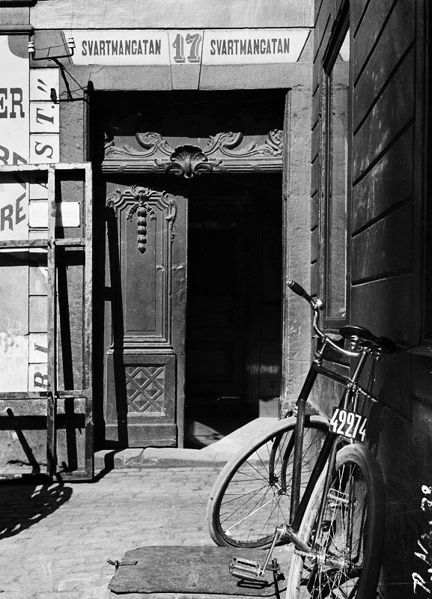 En cykel med nummerskylt baktill står utanför porten till Svartmangatan 17