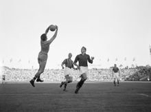 Råsundastadion. Fotbollsmatch mellan Djurgårdens IF och Proffsen. Målvakten Owe Nilsson fångar bollen, t.h. spelarna Hasse Jeppson och Bernt Iwegren