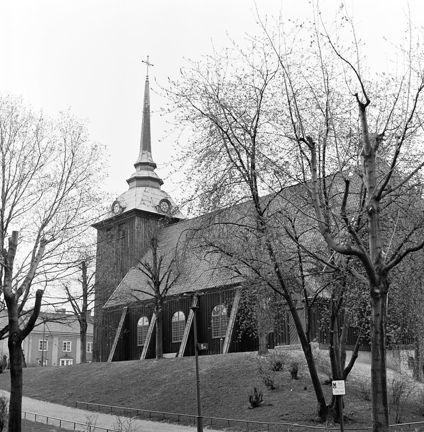 Kyrkan syns bakom kala träd.
