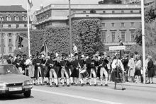 Reportage kring Kungabröllopet den 19 juni 1976. Ett spelmanslag med fanbärare tågar över Norrbro i riktning mot Slottet. En kvinna med skylten ""Leksands kompani"" går i täten