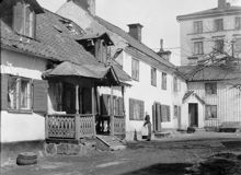 Gården till Brännkyrkagatan 139 A och B. En kvinna står bredvid verandan. Tidigare kv. Drakenberg. Nu Hornsbruksgatan 1, kv. Spettet