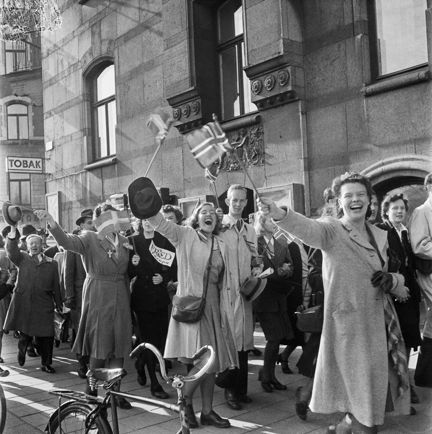 Fredsdagen den 7:e maj 1945.
Människor på gatan viftar med svenska och norska flaggor.