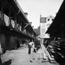Gårdssidan norrut vid Hantverkargatan 11 (i fonden). Tre män och ett hästekipage står vid en brädstapel. Fastigheten ägdes av Kungsholms Badhus AB. Då kv. Bryggaren, nu kv. Munklägret