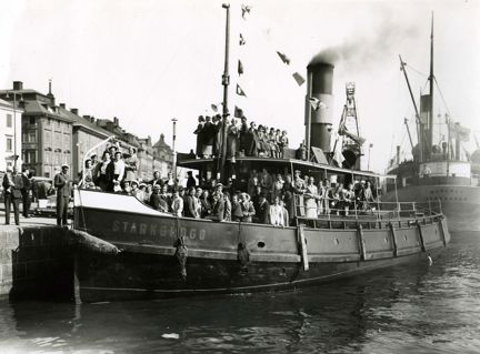 Svartvitt foto, ångbåt lägger ut från kaj.