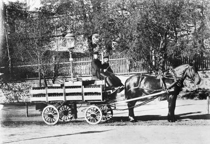 Hästdragen ölvagn från Mûnchenbryggeriet lastad med ölflaskor i backar, så kallade soffor, och med två ölutkörare på kuskbocken.