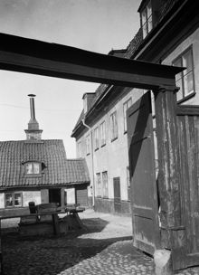 Västra Kvarngränd 2. Gården sedd norrut genom planket. Huset t.h. har framsidan mot Götgatan. Nuv. kv. Kvadraten, ung. vid Götgatan 92