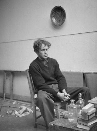 Svartvitt foto, man i 25-30-årsåldern sitter på en trästol i en ateljé. 