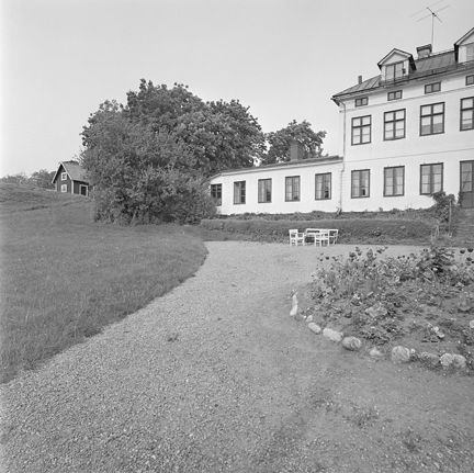 Svartvitt foto över gårdsplan framför byggnaden