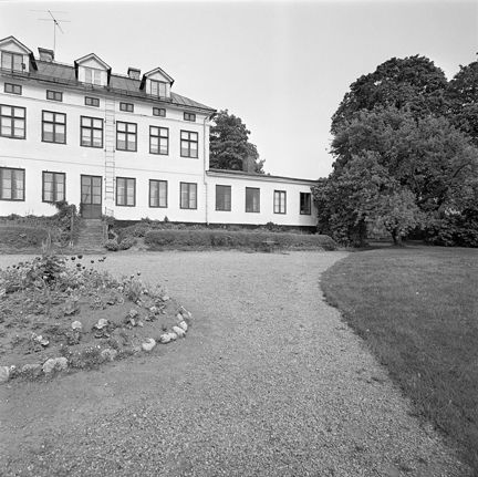 Svartvitt foto över gårdsplan framför byggnaden