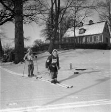 Fiskartorpet. Två flickor åker längdskidåkning på ""Skidans dag"". (7000 stockholmare följde Skid- och friluftsfrämjandets uppmaning att komma till Fiskartorpet och delta vid ""Skidans dag"")