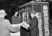 Män läser Svenska Dagbladet vid en tidningskiosk