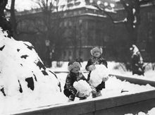 Barn som leker med snö vid Molins fontän i Kungsträdgården