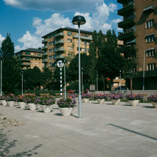 Blomsterurnor i Tessinparken vid T-banestationen Karlaplans norra uppgång. Vy åt nordost mot De Geersgatan