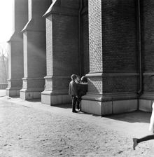 Tre ungdomar står tillsammans vid  Johannes kyrka, mellan strävpelarna