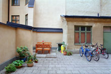 Bakgård med cyklar, uteplats och blomkrukor